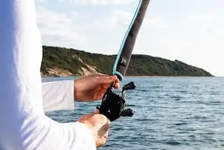 Angelrute wird über dem Ozean gehalten.