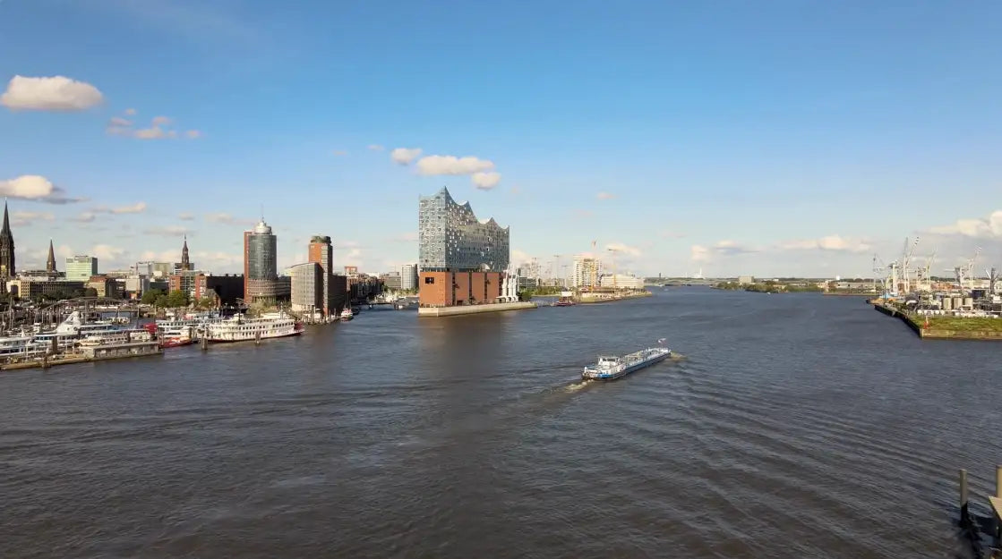 Das markante, glasverkleidete Elbphilharmonie-Konzertgebäude mit seinem Ziegelsockel ragt prominent in den Stadt-Skyline.