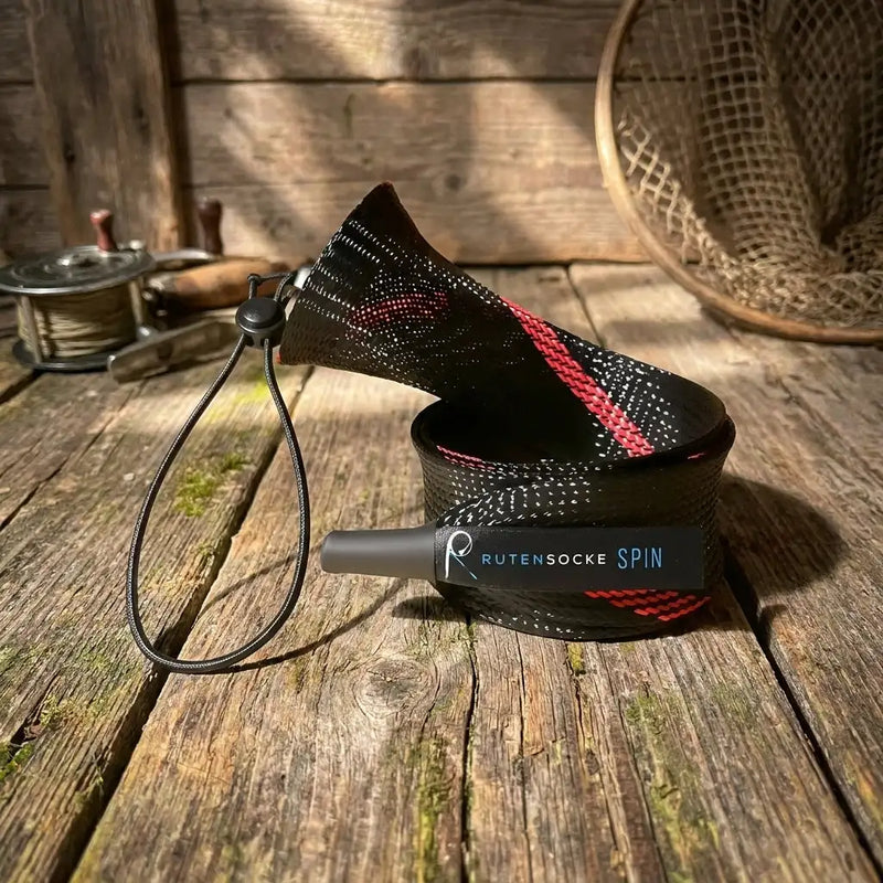 Schwarzer und roter gemusterter Rutensockel für die Spin-Fishing-Leine mit einer grauen Kappe.