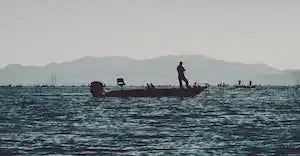 Silhouettiertes Gesicht auf einem Boot in unruhigen Gewässern.